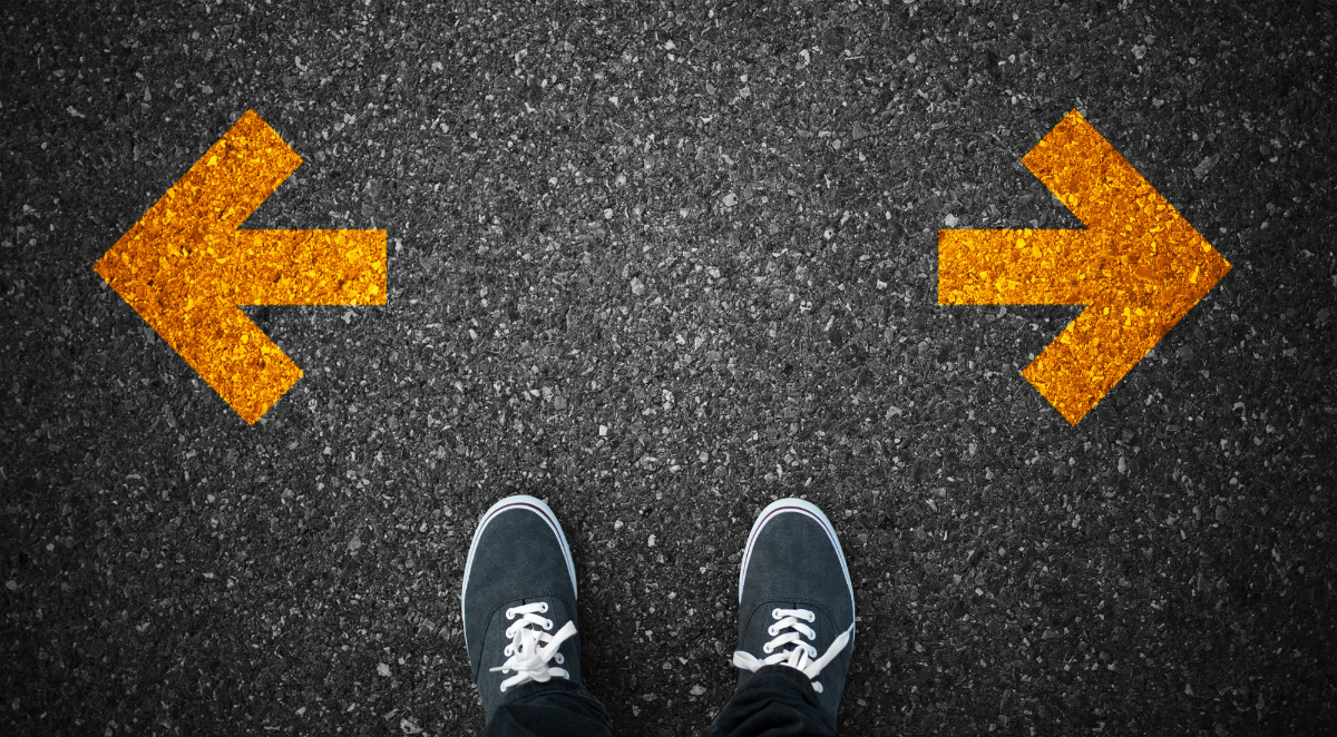 Man standing between two arrows