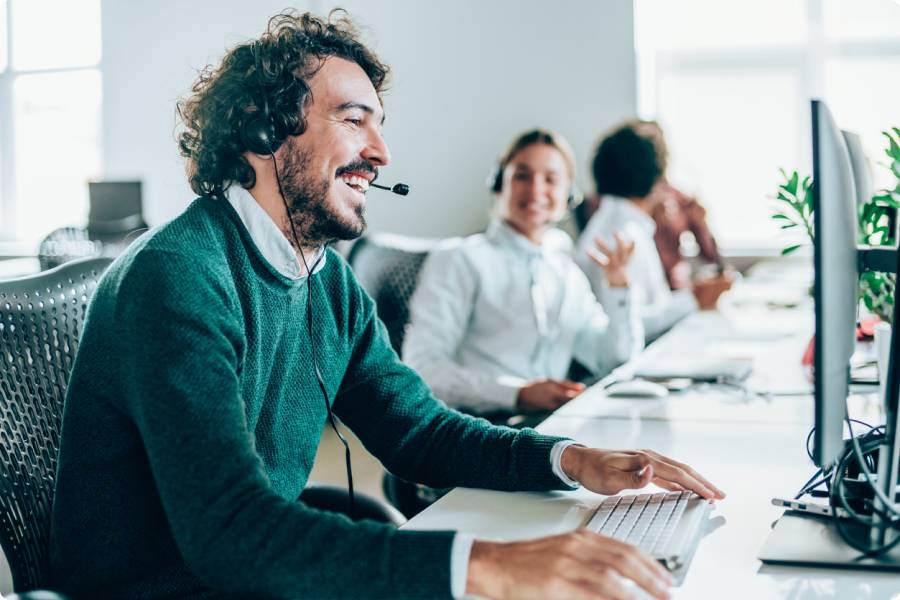 Supportperson with headphones looking happy.